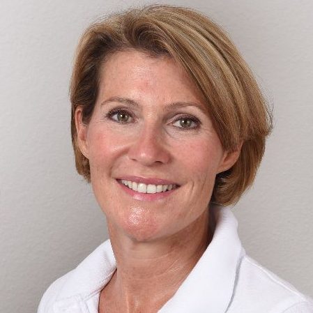 Portrait von Petra Maier Eine lächelnde Frau mit kurzem, blonden Haar in einem weißen Polohemd schaut in die Kamera.